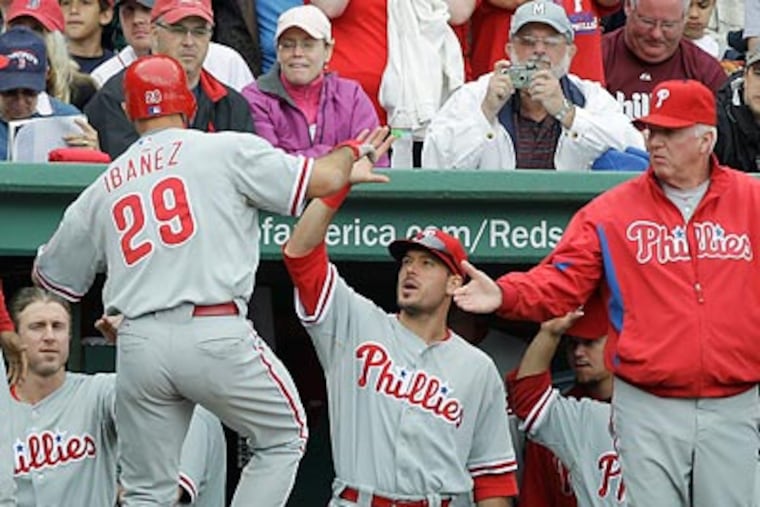 Raul Ibanez got congratulated in the dugout after hitting a two-run home run. (Charles Krupa/AP)