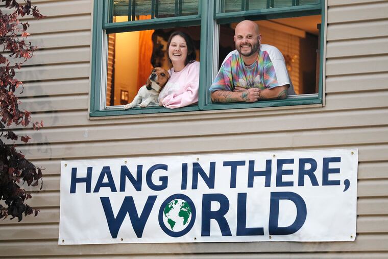 Cierra Smith, a restaurant manager, and Brandon Stallings, a chef, both out of work, display an inspirational message outside their Mantua home.