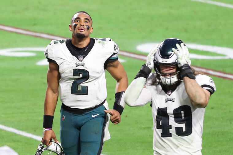Eagles quarterback Jalen Hurts (2) and Eagles linebacker Alex Singleton walk off the field following a 33-26 loss to the Arizona Cardinals.