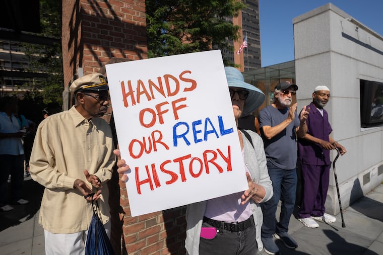 Kathryn Pyle holds a sign as activists rallied at the President's House, located at 6th and Market streets within the park, to protest the potential removal of the exhibit on slavery at the Liberty Bell Center, in Philadelphia, September 19, 2025. During the rally, the group led a nine-minute tribute to the nine enslaved people that George Washington brought to the Philadelphia residence.