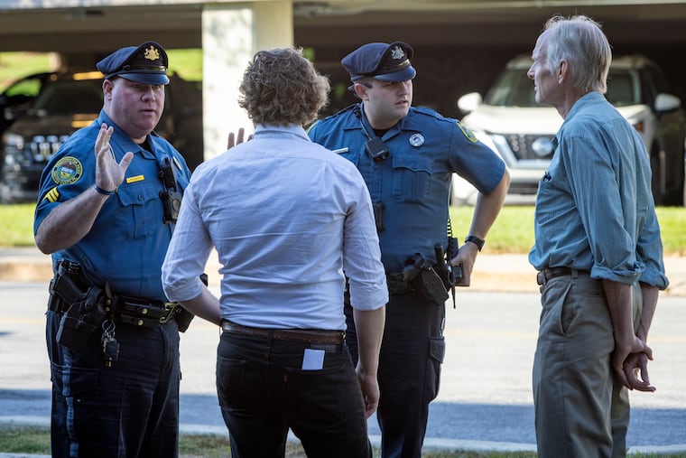 Officers with the Tredyffrin Township Police Department speak with protesters for environmentalist group Earth Quaker Action Team at Vanguard headquarters in Malvern in 2022. Activists have urged the second-largest investment company to divest from fossil fuels, but pro-oil, gas, and coal legislators in energy states have pressed Vanguard to keep investing in the sector.