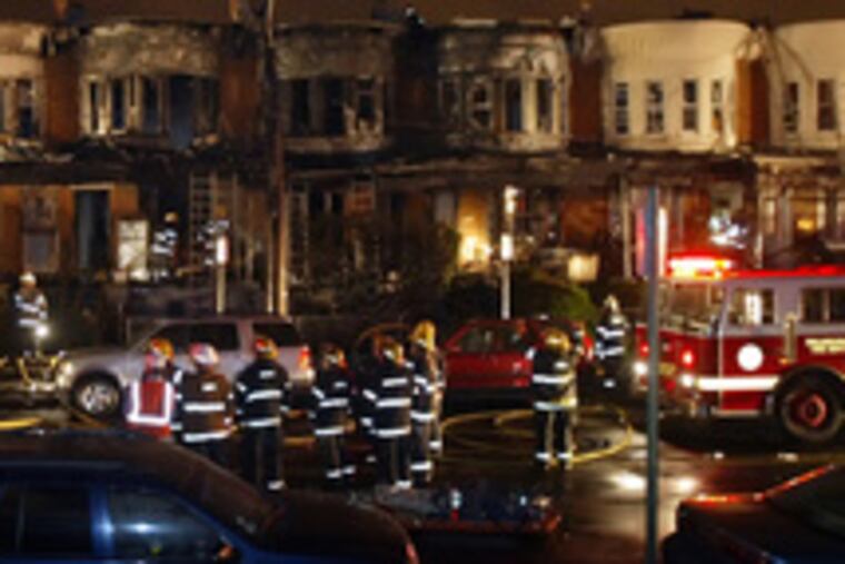 Firefighters stand by after bringing a three-alarm blaze under control in Cobbs Creek. Three people were hospitalized.