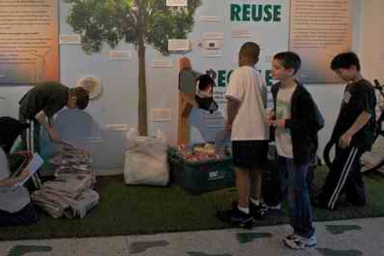 Schoolchildren gather in the exhibit's reuse and recycle area. Children also liked preserved animals and massive fossilized bones, quizzes - and a few touch-friendly mastodon bones.