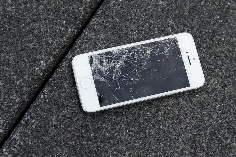 This Aug. 26, 2015 photo shows an Apple iPhone with a cracked screen after a drop test from the DropBot, a robot used to measure the sustainability of a phone to dropping, at the offices of SquareTrade in San Francisco. Independent repair shops complain that it is often hard to repair Apple products. (AP Photo/Ben Margot, File)
