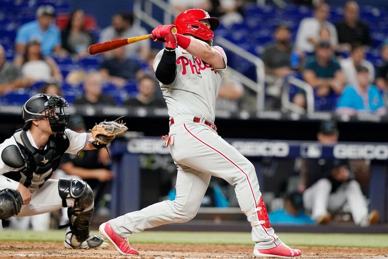 Philadelphia Phillies' Bryce Harper, right, watches after hitting a solo home run during the sixth inning of a baseball game against the Miami Marlins, Wednesday, Sept. 14, 2022, in Miami. At left is Miami Marlins catcher Nick Fortes. (AP Photo/Lynne Sladky)