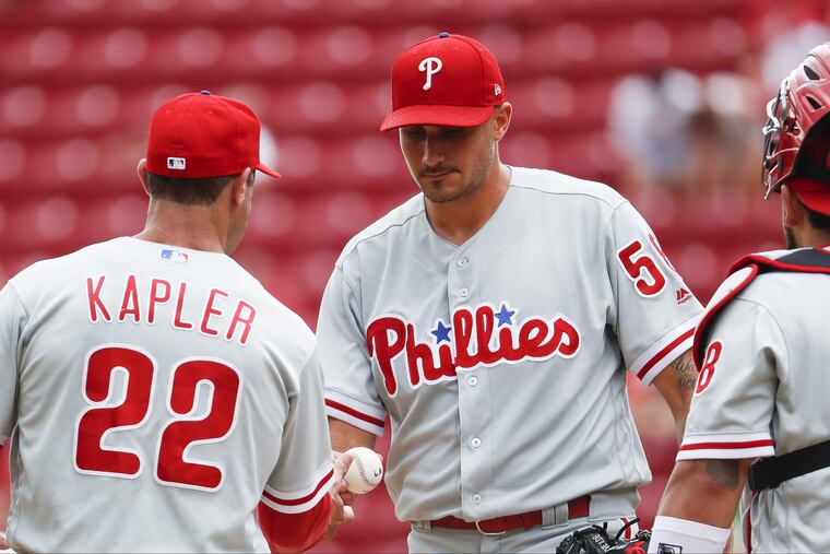 Phillies starter Zach Eflin hands the ball to Gabe Kapler as he is pulled in the sixth inning against the Reds.
