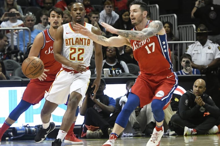 Sixers’ guard JJ Redick passes in front of Atlanta Hawks guard Isaiah Taylor (22) during the first half of an NBA basketball game on Friday.