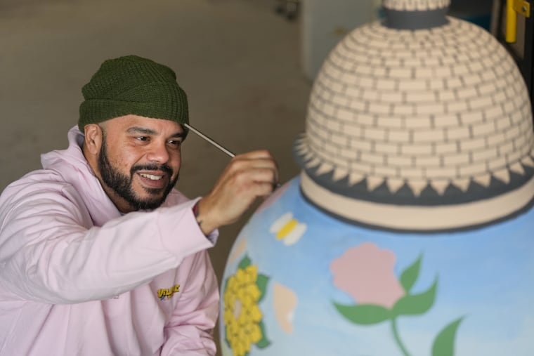 Artist Robert Lugo with his work, a "monumental ceramic vessel" that depicts the transformation from Bucks County Jail to the Michener Art Museum, in his Wyncote studio, Jan. 16, 2026.