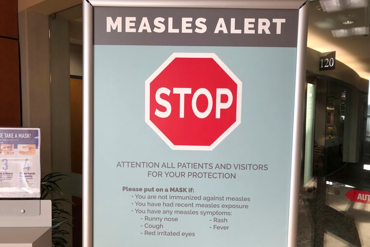 A sign warning patients and visitors of a measles outbreak at The Vancouver Clinic in Vancouver, Wash.