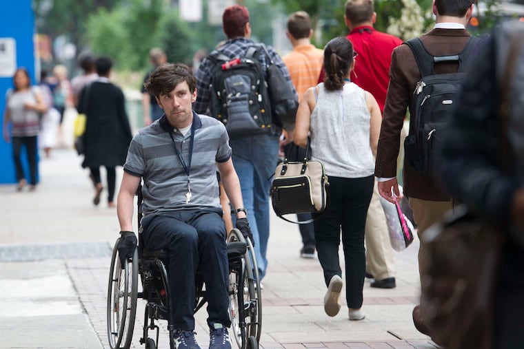 Liam Dougherty was a plaintiff in a suit accusing the city of violating federal protections for people with disabilities with inaccessible sidewalks and curb ramps. He is shown here in a 2019 file photo.