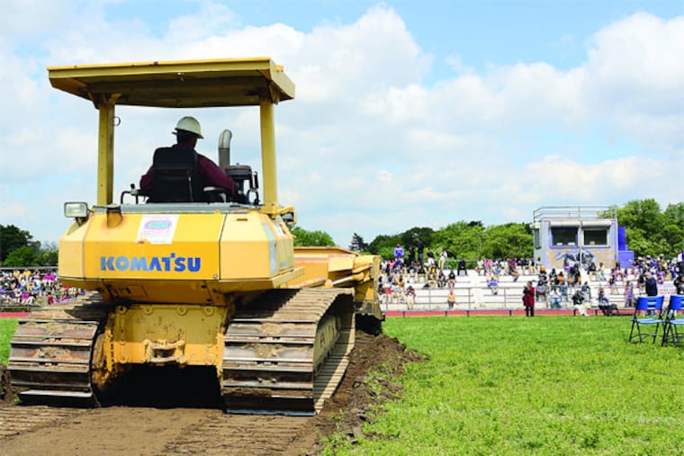 A bulldozer moves some earth during the official ground-breaking ceremony May 13, 2013, for the $1.5 million renovations to the Camden High School football field. The field has been in desperate need of renovations for while- no lights, scrapy field with holes, bleachers are in terrible condition. The Eagles donated a portion of the costs. ( TOM GRALISH / Staff Photographer )