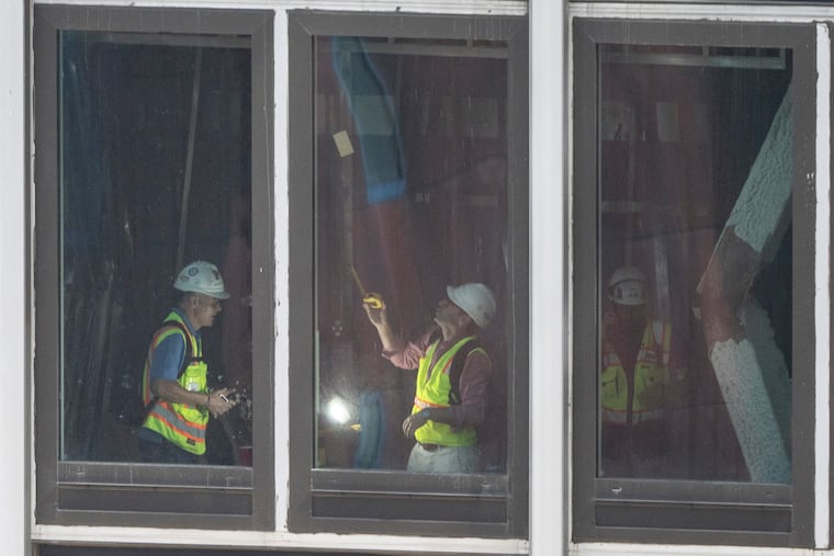People inspect a buckled support beam inside 235 East 42nd Street, Wednesday, July 8, 2026, in New York.