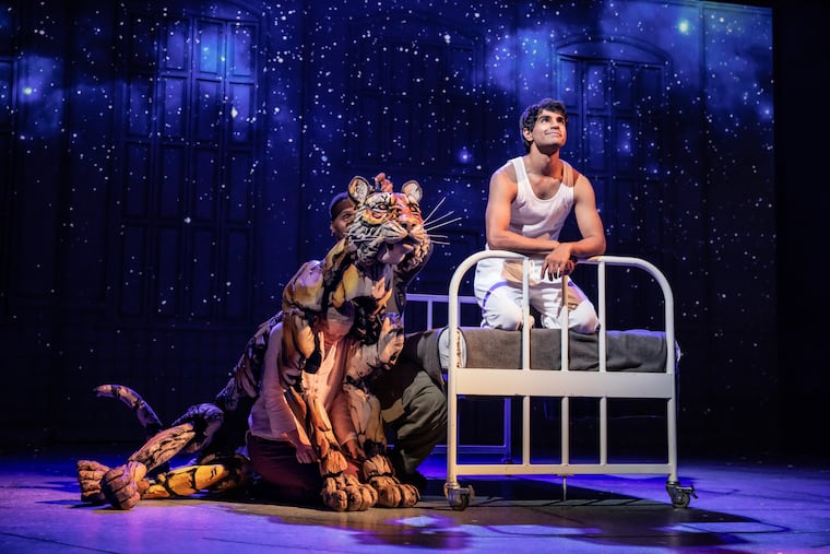 Taha Mandviwala as "Pi" and puppeteers Anna Leigh Gortner, Shiloh Goodin, and Toussaint Jeanlouis as "Richard Parker" in the national tour of "Life of Pi."