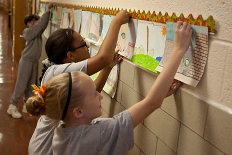 Students (from left) Zach Persechino, Ashley Wilburn and Patricia Templeton post drawings at Good Shepherd, Ardsley. (Ron Tarver/Staff)