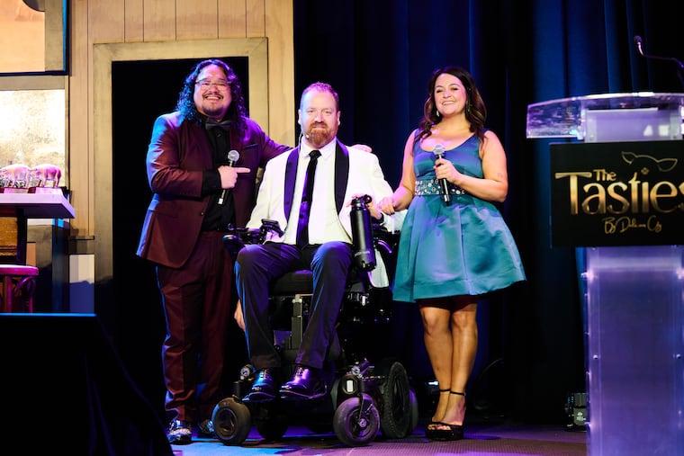 (Left to right) "Delicious City" podcast cohosts Dave Wez, Eli Kulp, and Marisa Magnatta post onstage at The Tasties culinary awards at Live! Hotel & Casino on Feb. 2, 2026.