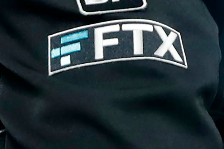 The FTX logo appears on home plate umpire Jansen Visconti's jacket at a baseball game with the Minnesota Twins in 2022 in Minneapolis.
