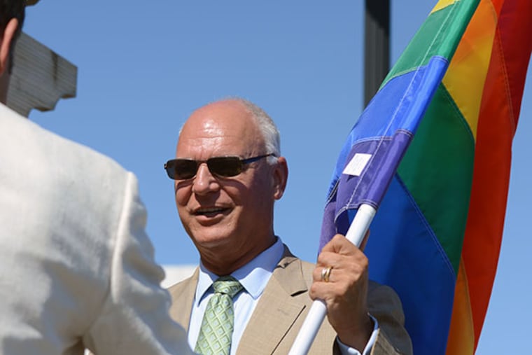Atlantic City Mayor Don Guardian holds the rainbow flag before it was raised at Park Place on the Atlantic City Boardwalk on Monday, June 16, 2014. (Andrew Thayer/Staff Photographer)