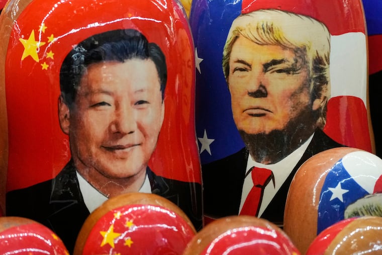 Traditional Russian wooden dolls depict China's President Xi Jinping and President Donald Trump at a souvenir shop in St. Petersburg, Russia.