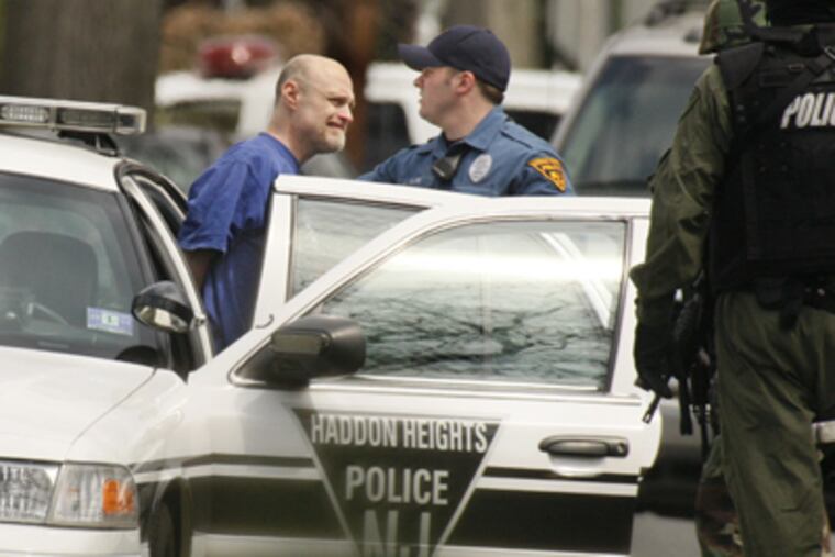 The man who had been allegedly keeping police at bay on Wayne Avenue in Haddon Heights is put into a police car after surrendering earlier today. (Elizabeth Robertson / Staff Photographer)