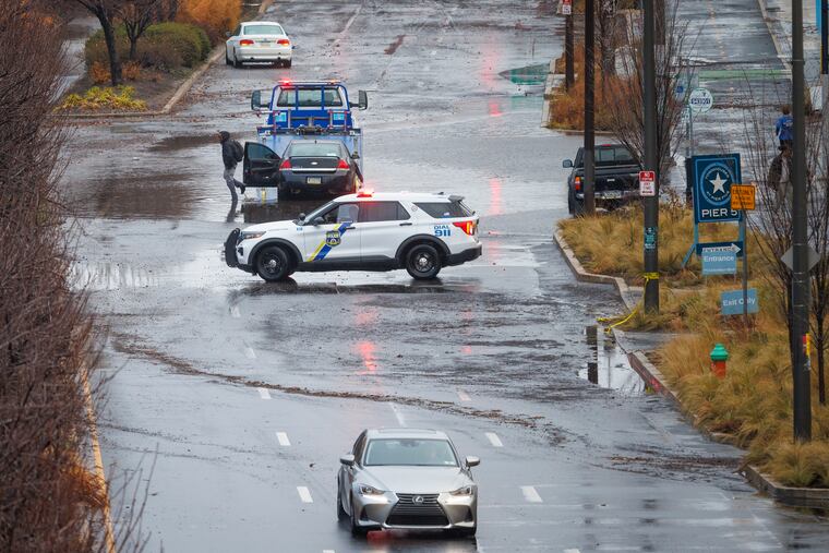 Philadelphia police shut off Delaware Avenue near Race Street in Center City as a result of flooding in December. More of the same is possible Sunday.