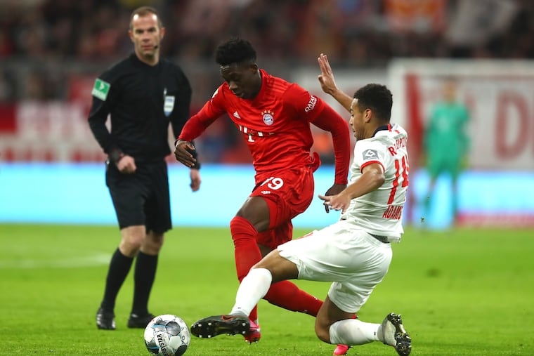 American midfielder Tyler Adams of RB Leipzig (right) playing against Canadian left back Alphonso Davies of Bayern Munich (center) in February.
