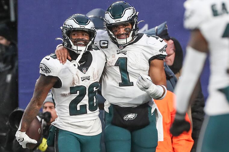 Eagles running back Miles Sanders (26) celebrates his fourth-quarter touchdown run against the Giants with QB Jalen Hurts.