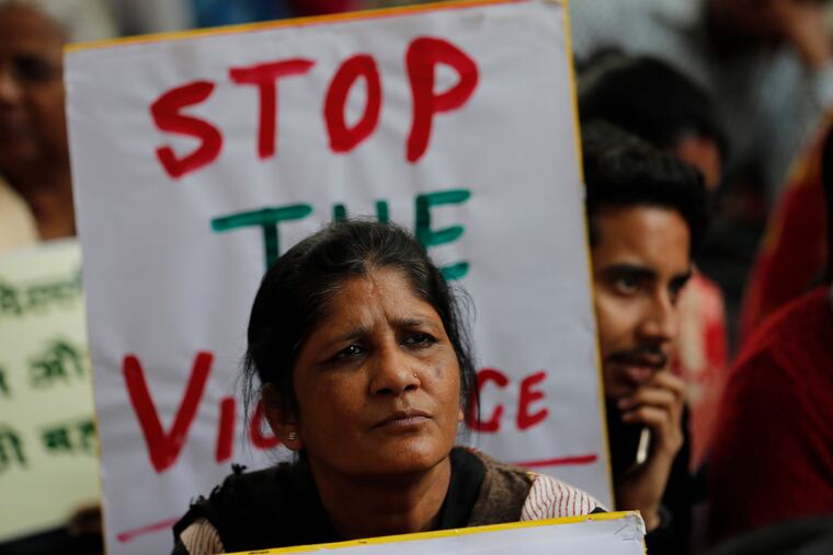 Activists from different organizations hold banners calling for peace and communal harmony following violence in New Delhi, India, Wednesday, Feb. 26, 2020. At least 20 people were killed and 189 injured in three days of clashes in New Delhi that coincided with U.S. President Donald Trump's first state visit to India, with the death toll expected to rise as hospitals continue to take in the wounded, authorities said Wednesday.