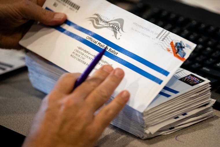 Dave Turnier processes mail-in ballots at at the Chester County Voter Services office in West Chester.