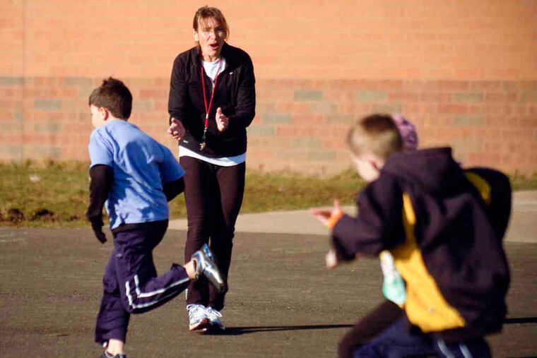 Judy Wexler cheers on kids as they run at Bridge Valley Elemen- tary School near Doylestown. The program is in its fourth year.