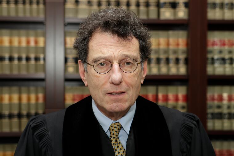 FILE - This Jan. 11, 2018 file photo shows Judge Dan Polster in his office, in Cleveland. Attorneys representing eight drug distributors, pharmacies and retailers facing trial for their roles in the national opioid crisis are seeking to disqualify the federal judge overseeing their cases saying he’s shown clear bias in his efforts to obtain a multi-billion dollar global settlement. The motion was filed late Friday, Sept. 13, 2019, in U.S. District Court in Cleveland, where Judge Dan Polster presides over most of the 2,000 lawsuits filed by state, local and tribal governments. Polster has not responded. (AP Photo/Tony Dejak, File)