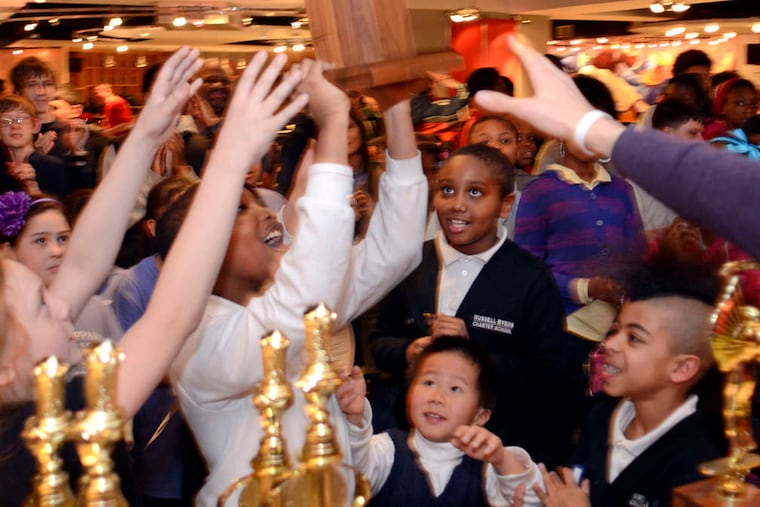 Members of the Russell Byers Charter School chess team reach for their first-place elementary school city chess championship award at the Philadelphia Scholastic Chess League City Championships in 2013.