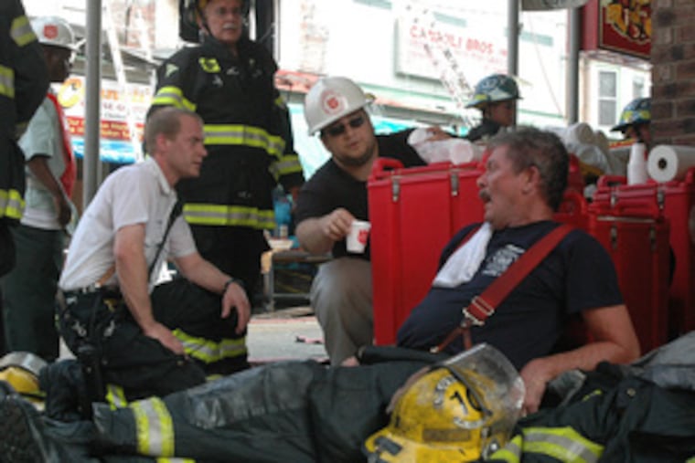 Firefighter Michael Welloch (right), from Engine Company 10, lies exhausted after helping to battle the fire.