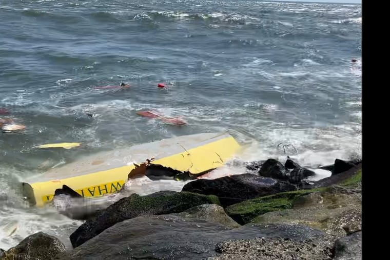 Wreckage of a sailboat that struck a jetty and sank Wednesday off the beach at Avalon, N.J. Ten people wearing life jackets were rescued from the water and no injuries were reported.