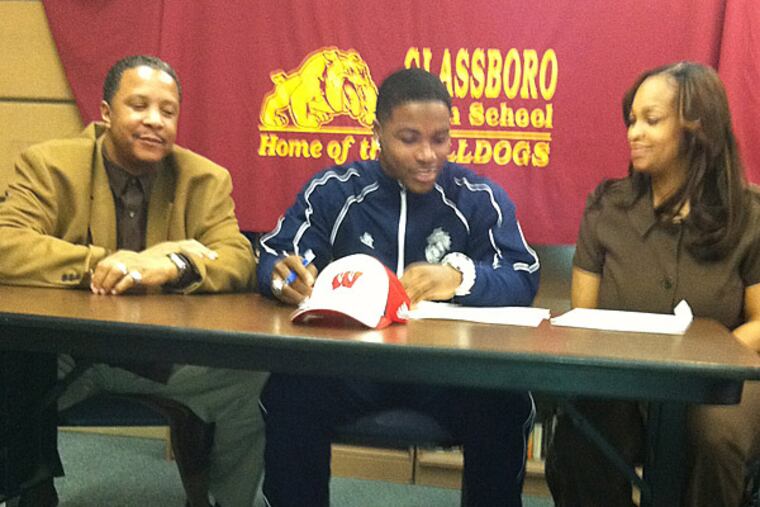 Glassboro's Corey Clement signs with Wisconsin as dad Stephen and mom Latonya look on. (Phil Anastasia/Staff)