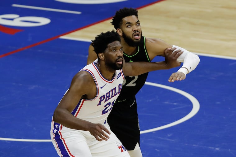 Joel Embiid and Minnesota center Karl-Anthony Towns fight for position during Saturday's game, Embiid's first since returning from a knee injury.