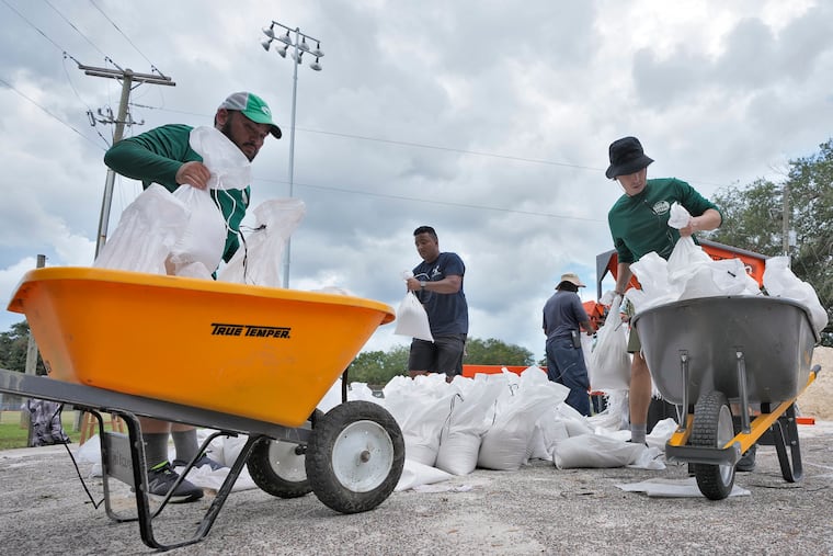 Members of the Tampa, Fla., Parks and Recreation Dept., help residents with sandbags on Monday in Tampa, Fla. Residents along Florida's gulf coast are making preparations for the effects of Hurricane Idalia.
