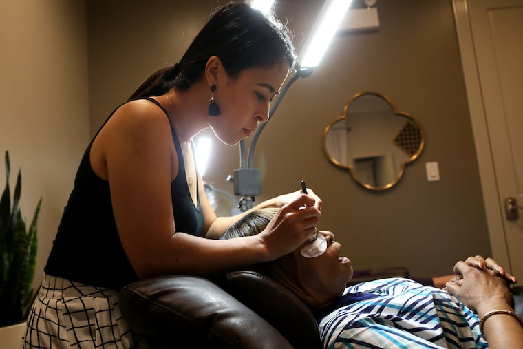 Maria Santacruz, owner of Fabulash Beauty put eye lash extensions on Diane Drummer, at her business on Wednesday, July 3, 2019 in Chicago. Santa Cruz is Latina and has owned the business for 3 years. (Stacey Wescott/Chicago Tribune/TNS)