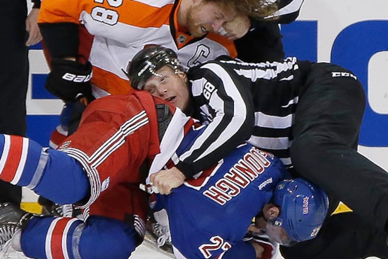 Linesmen Scott Driscoll (68) and Mark Shewchyk (92) wrestle New York Rangers defenseman Ryan McDonagh (27) and Philadelphia Flyers center Claude Giroux (28). (AP Photo/Kathy Willens)