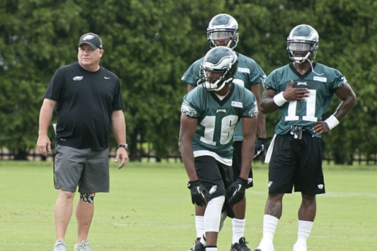 Chip Kelly works with the wide receivers. (Ron Tarver/Staff Photographer)
