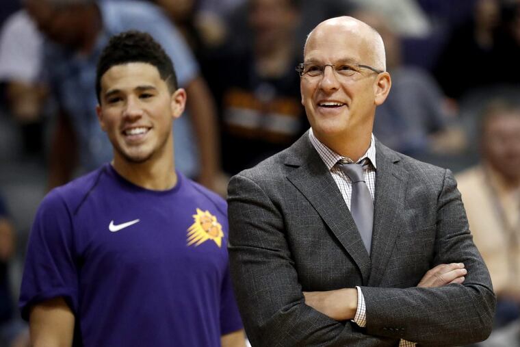 Suns coach Jay Triano, next to guard Devin Booker, smiles during a game in October.