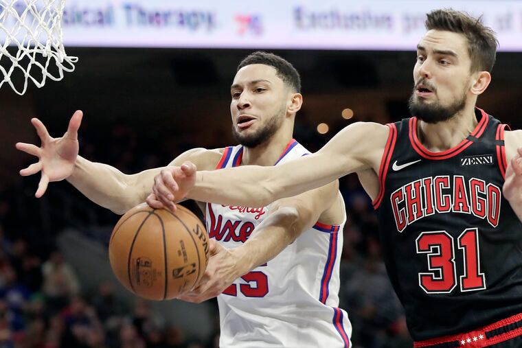 Ben Simmons fights for a rebound against the Bulls' Tomas Satoransky during the second quarter of the Sixers' 100-89 win Friday night.