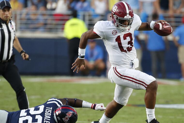 Alabama quarterback Tua Tagovailoa (13) evades a tackle by Mississippi defensive end Tariqious Tisdale (22) during the first half of their NCAA college football game, Saturday, Sept. 15, 2018, in Oxford, Miss.