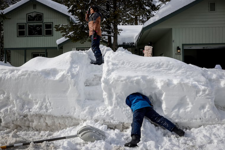 Miles Gomez, 9, plays with his twin brother, Edison, after a series of storms in the South Lake Tahoe, Calif., region last week. More is due out that way this weekend.