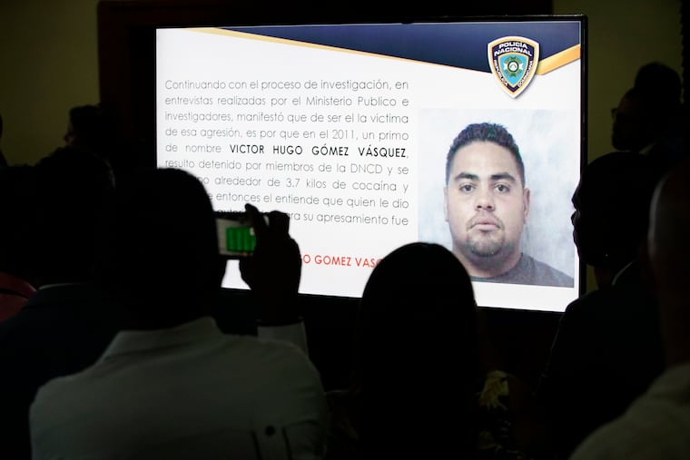 Journalists take pictures of a projection of a man identified by authorities as Victor Hugo Gomez Vasquez, a suspected mastermind of the attack against former Boston Red Sox slugger David Ortiz in Santo Domingo, Dominican Republic, Wednesday June 19, 2019.