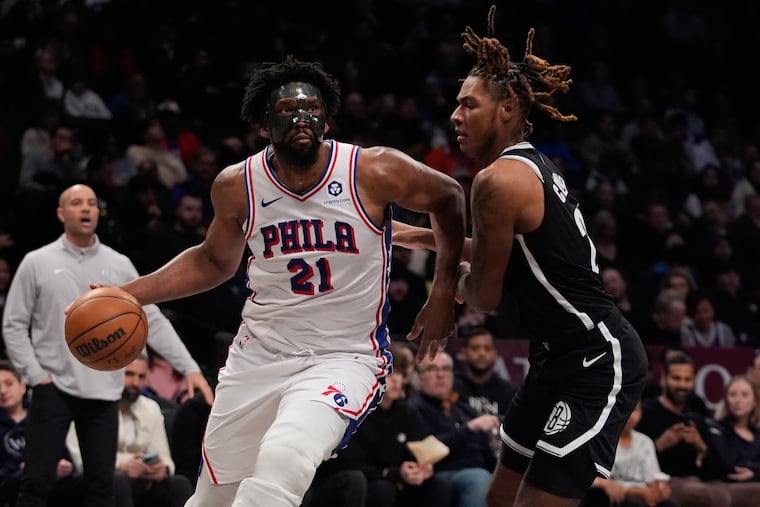 Sixers center Joel Embiid drives past Brooklyn's Jalen Wilson during the second half Saturday.