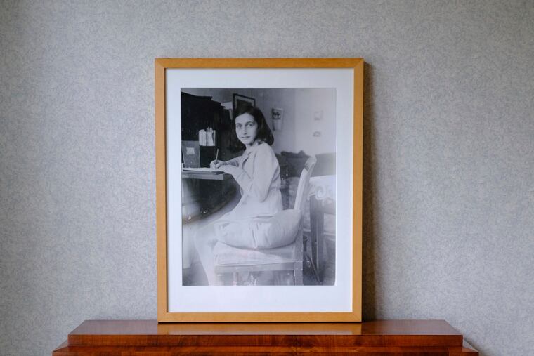 A photo of Anne Frank stands on a replica of the writing desk she once used in her family's former apartment in Amsterdam, during an event to mark what would have been Anne Frank's 90th birthday, in Amsterdam, Netherlands, Wednesday, June 12, 2019. On the day Anne Frank would have turned 90, the museum dedicated to keeping alive her story has brought together schoolchildren and two of the Jewish diarist's friends at the apartment where she lived with her family before going into hiding from Nazis who occupied the Netherlands during World War II. (AP Photo/Michael C. Corder)