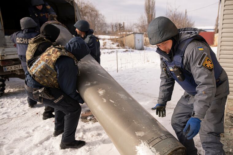 Ukrainian emergency services employees push the remains of an S-300 missile fired by Russian forces onto a truck in Kharkiv, Ukraine, on Friday.