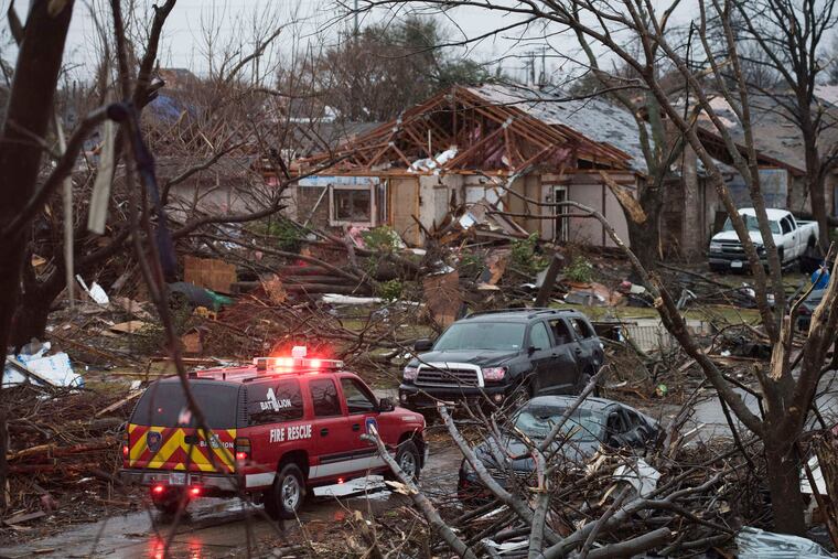 An emergency vehicle drives through a neighborhood in Rowlett, Texas, the day after it was struck by a tornado, injuring 23 people and damaging 600 homes.