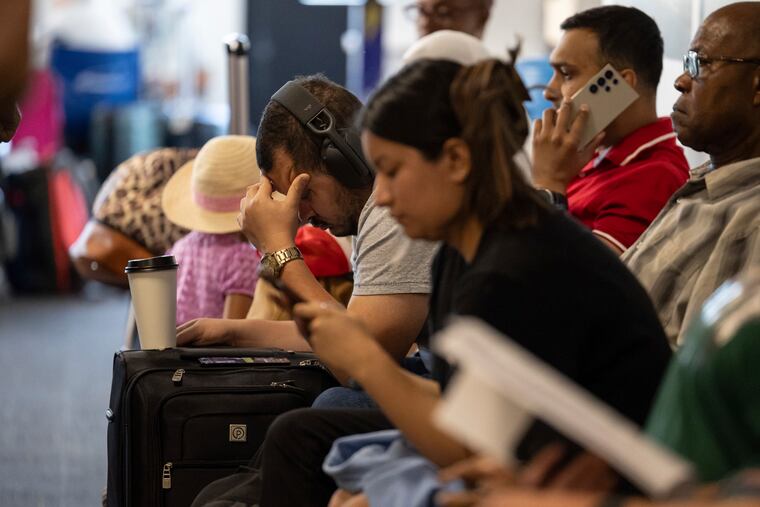 Customers wait at a departure area for Spirit Airlines at LaGuardia Airport in New York on Friday after a faulty CrowdStrike update caused a major internet outage for computers running Microsoft Windows.