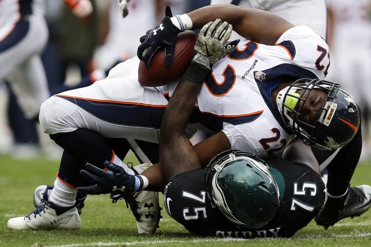 Eagles defensive end Vinny Curry bends back Denver Broncos running back C.J. Anderson during the first quarter on Sunday.